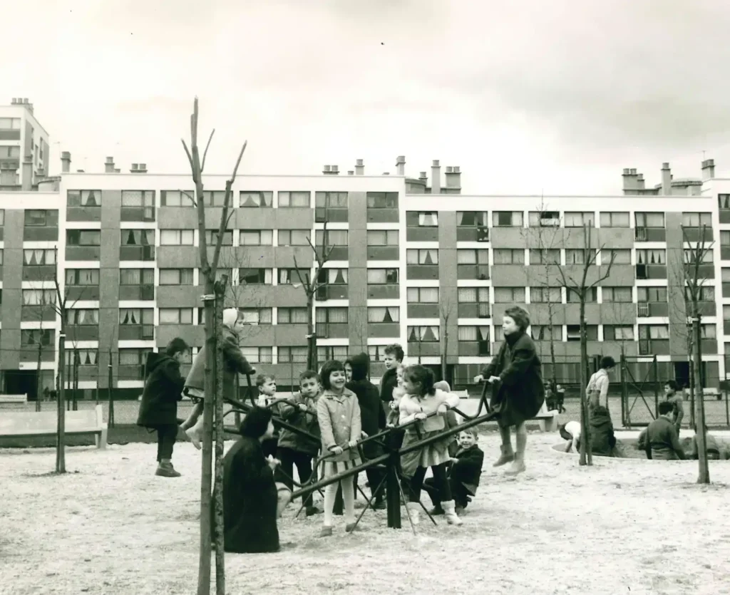 Jeux d'enfants dans un square devant un immeuble de grand ensemble, années 1960